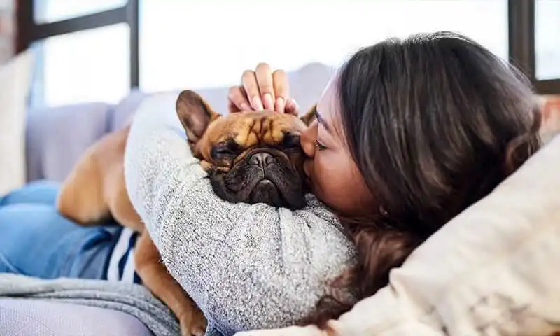 A woman kissing her dog